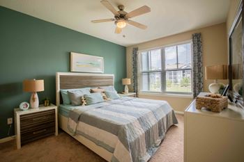 A bedroom with a bed and a ceiling fan